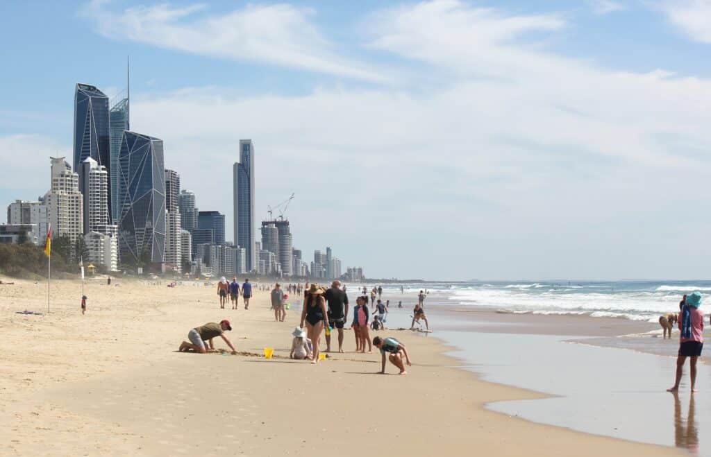 People enjoying a day at the beach in front of high rise apartment buildings at Broadbeach, Gold Coa